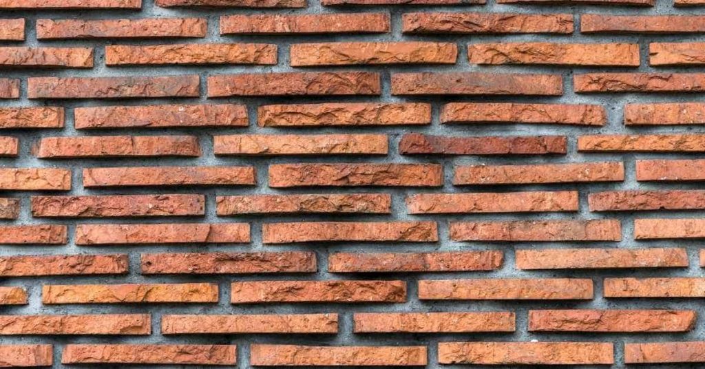 Close-up of thin red brick wall pattern with mortar joints