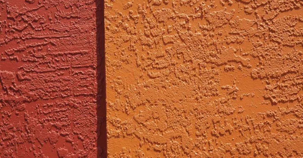 Close-up of two different colored stucco wall sections with textured surface
