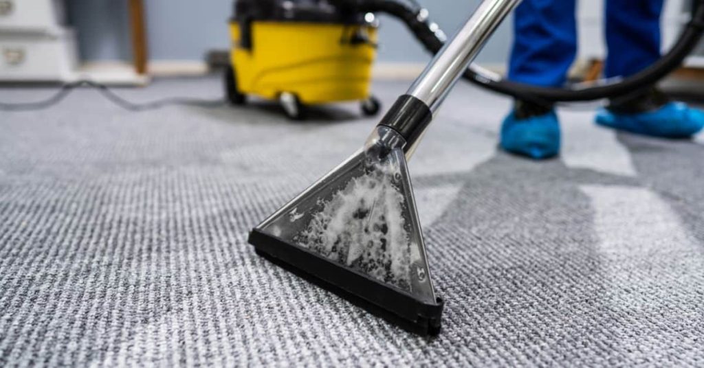 Closeup of carpet cleaning extraction tool on gray carpet