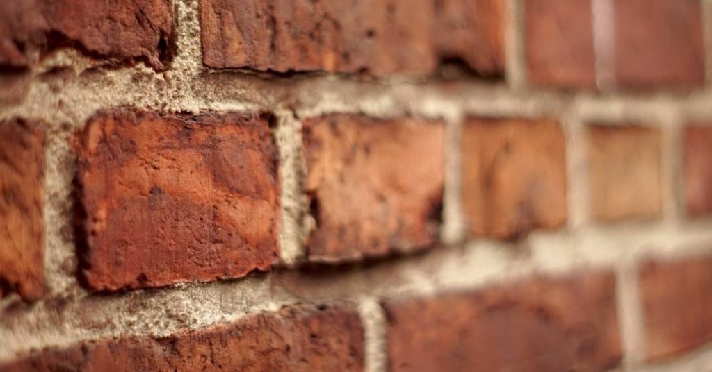 Closeup of red brick wall with light gray mortar