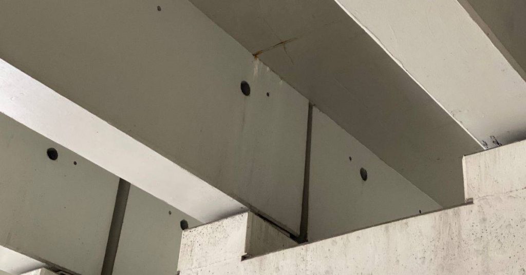 Concrete beams connected to a concrete column indoors