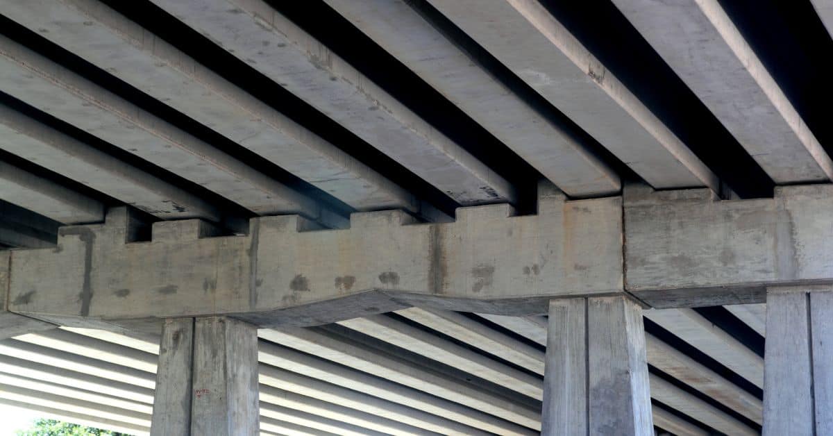 concrete beams supported by concrete columns under a bridge