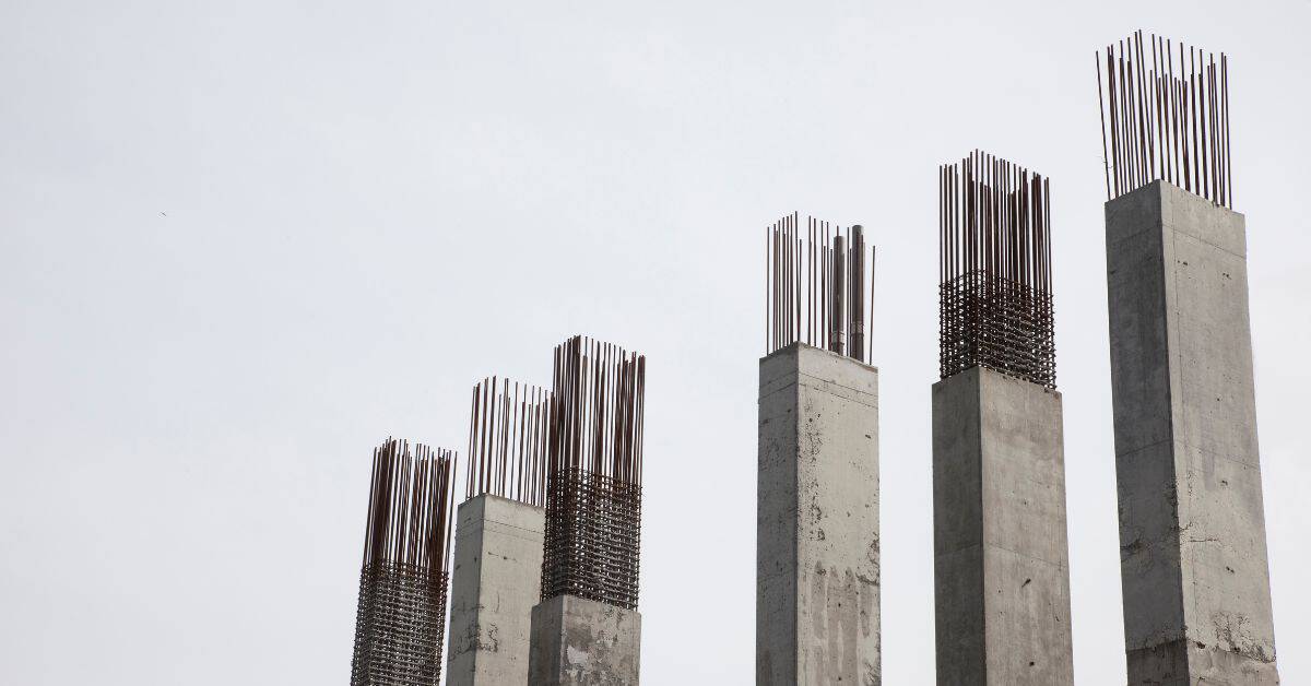Concrete columns with exposed vertical rebar extending upward