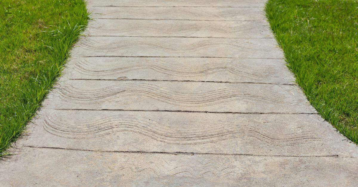 Concrete pathway with wave pattern textures between grass edges