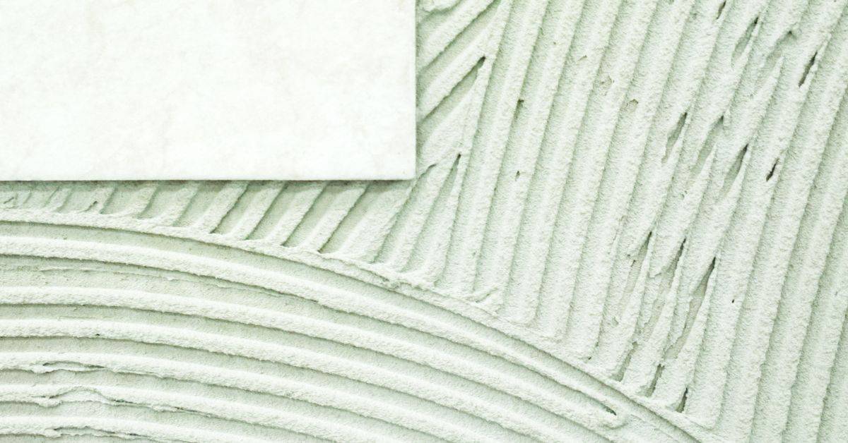 Tile placed on patterned adhesive with grooved texture