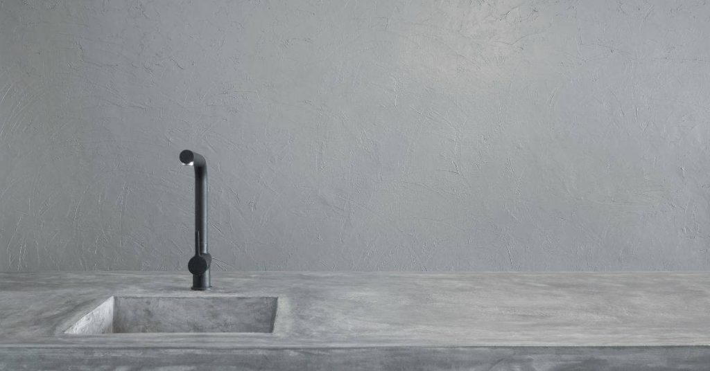 Concrete countertop with integrated sink and black faucet