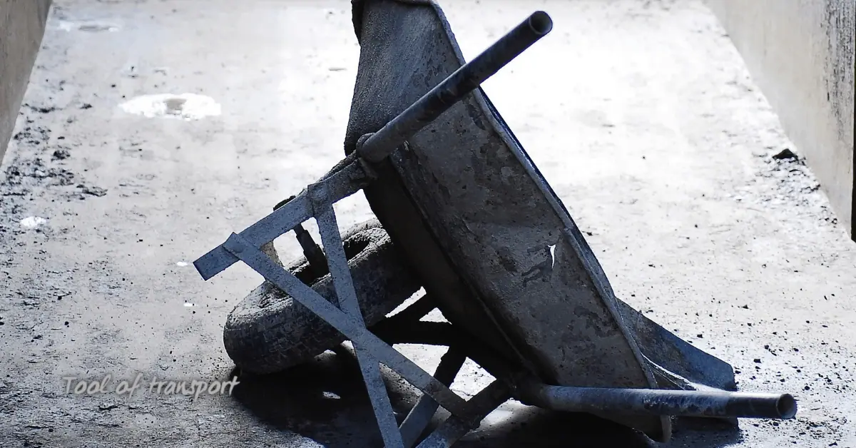 Empty metal wheelbarrow resting on concrete floor