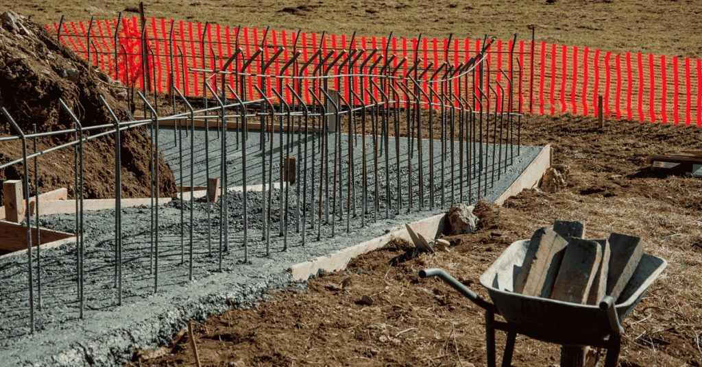 Concrete foundation footing with vertical rebar and wheelbarrow