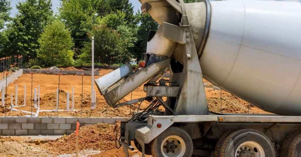 Concrete mixer truck pouring foundation at construction site