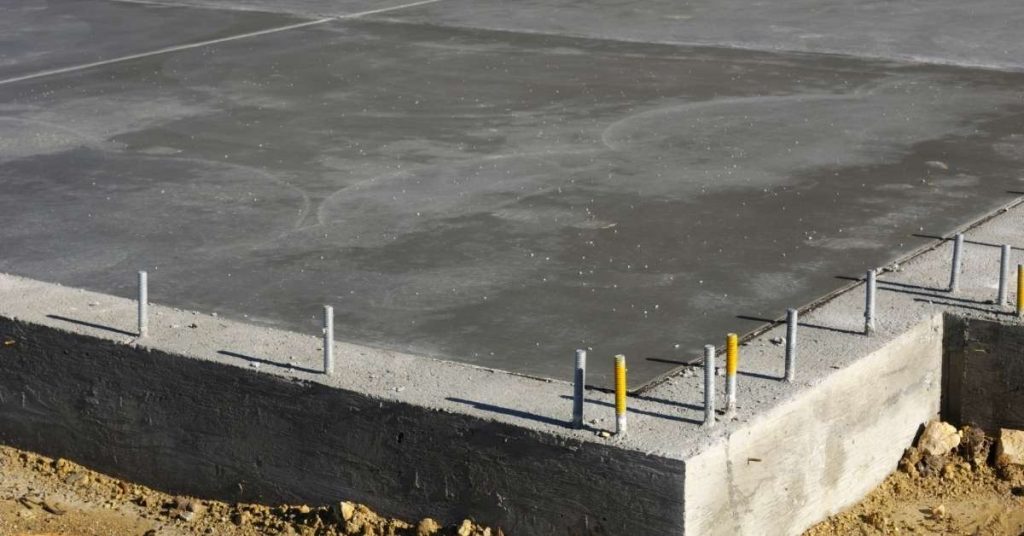 Concrete slab foundation with metal anchor bolts embedded