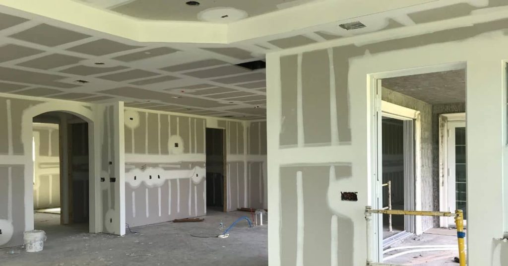 Drywall panels with taped and mudded seams in unfinished room