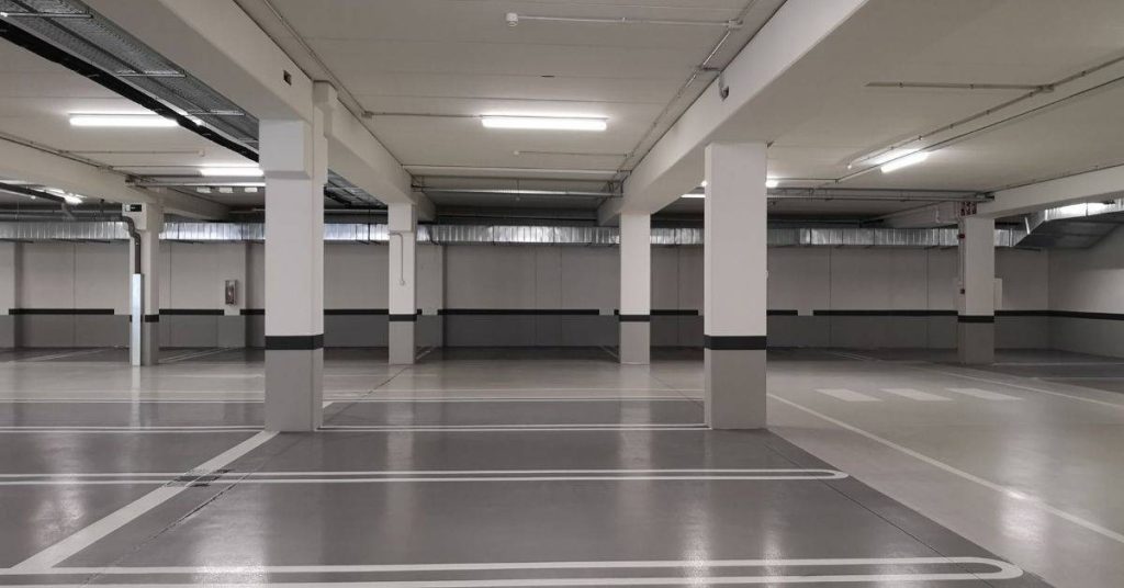 Empty concrete parking garage with support columns and painted lines