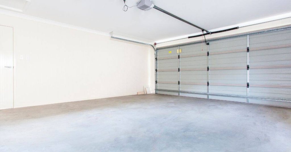 Empty garage with concrete floor and closed metal door