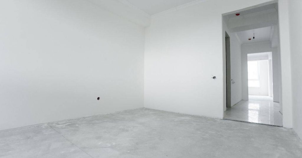 Empty unfinished room with smooth white plastered walls