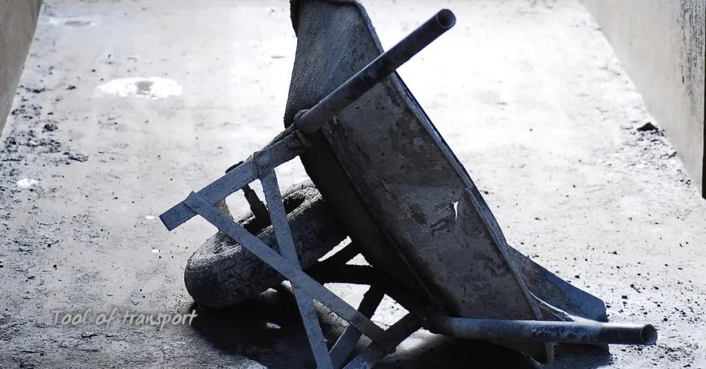 Empty wheelbarrow on concrete floor in shaded area
