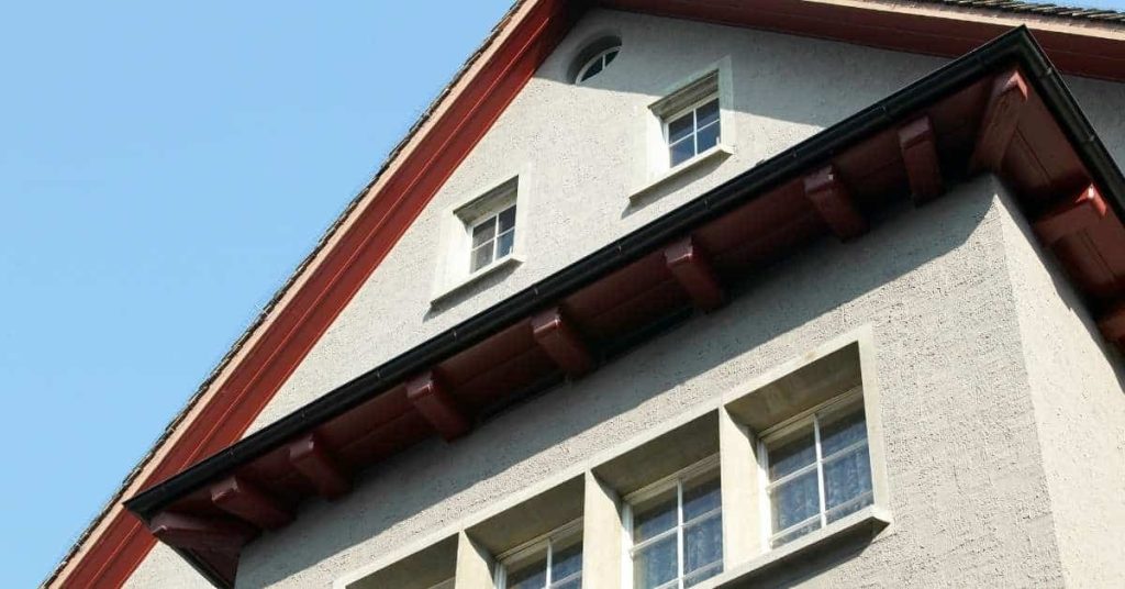 Exterior stucco wall with multiple windows under clear sky