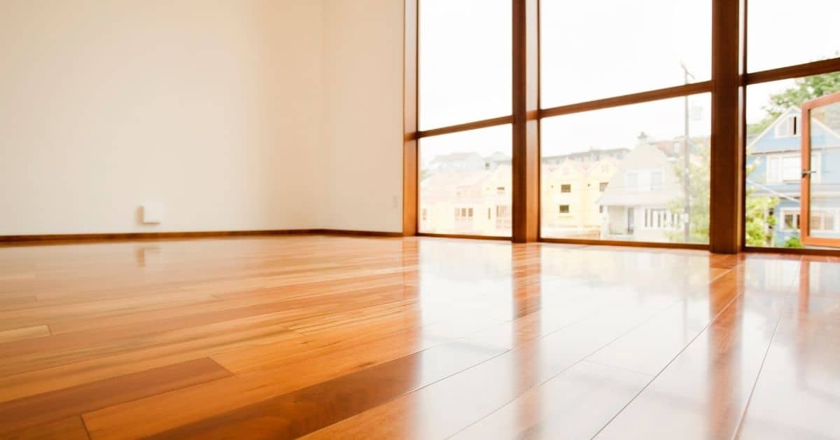 Shiny polished hardwood floor with large window and natural light