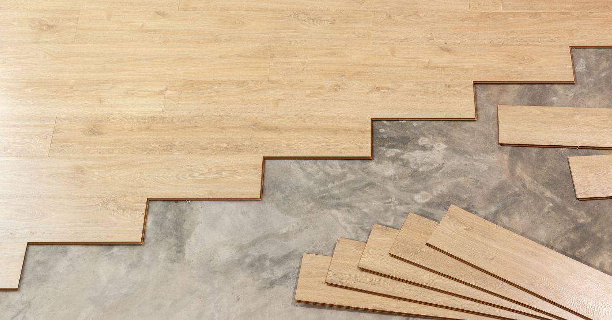 Light wood vinyl plank flooring partially installed on concrete floor