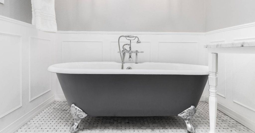 Freestanding bathtub on patterned tile floor in bathroom