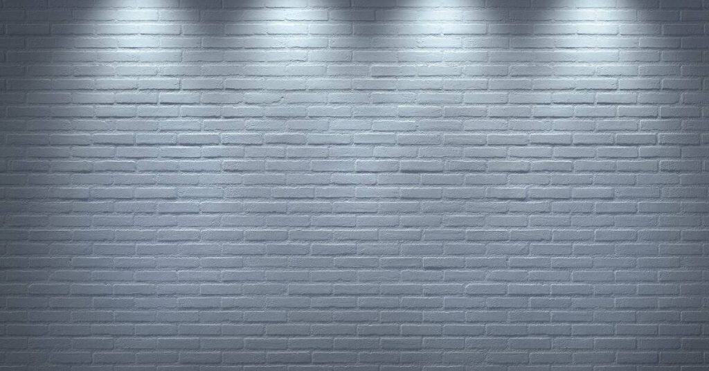Gray painted brick siding wall under focused lighting