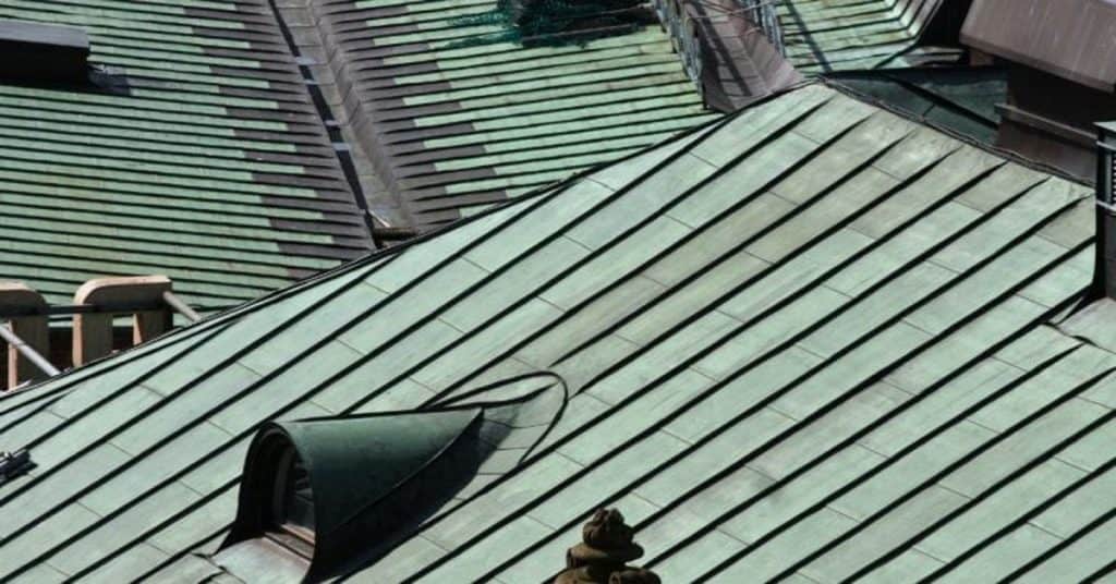 Green patina copper seam metal roof under sunlight