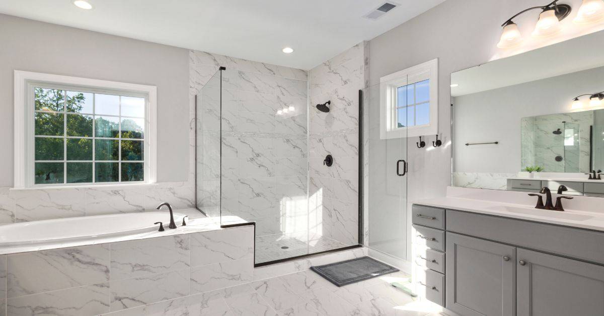 Modern bathroom with marble tiles, bathtub, and walk-in shower