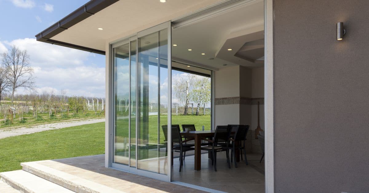 Sliding glass doors open to outdoor patio with table and chairs