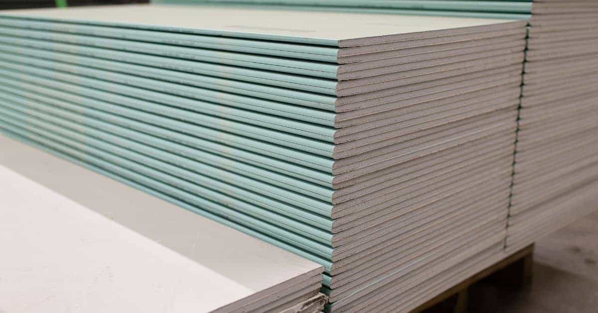 Stacks of green drywall sheets on a wooden pallet