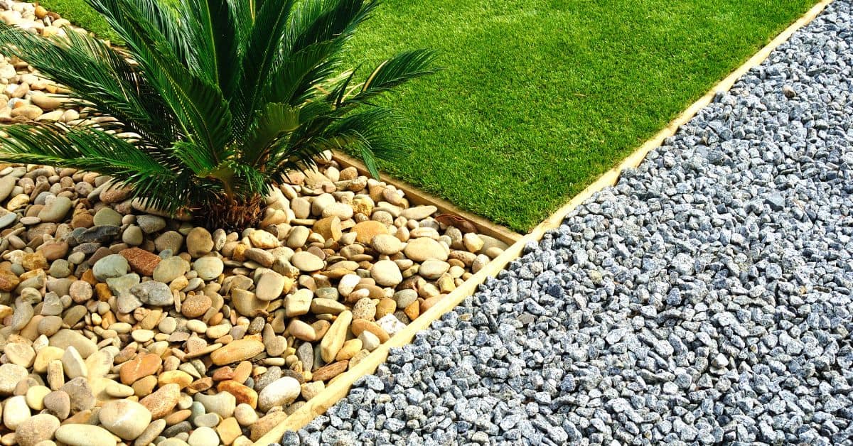 Section of garden with smooth and crushed gravel and green grass