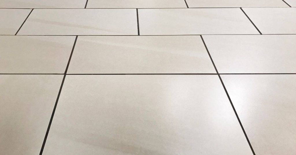 Light beige porcelain floor tiles with dark grout lines