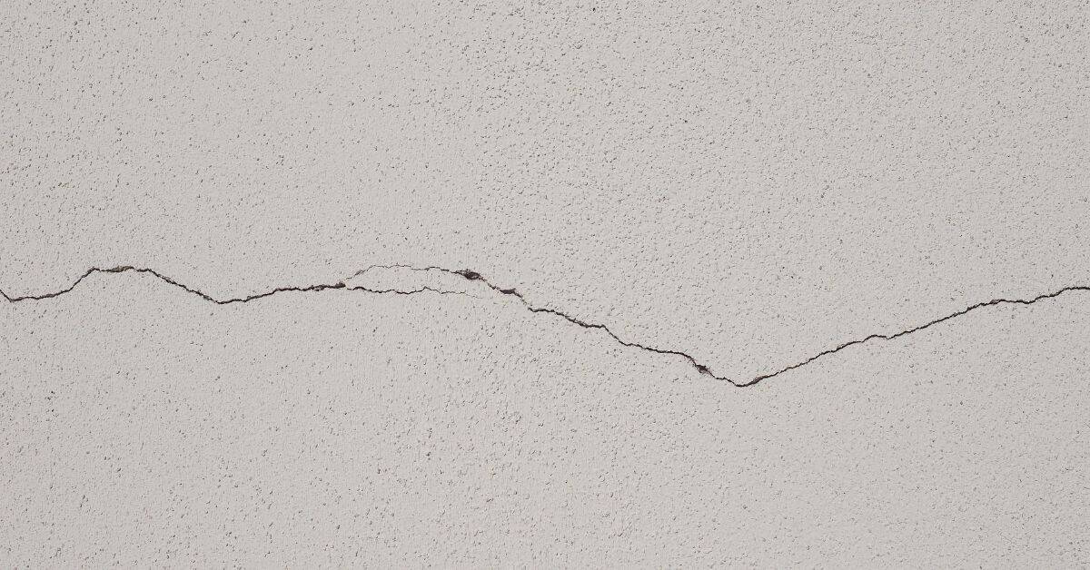 close-up of horizontal crack in white stucco wall