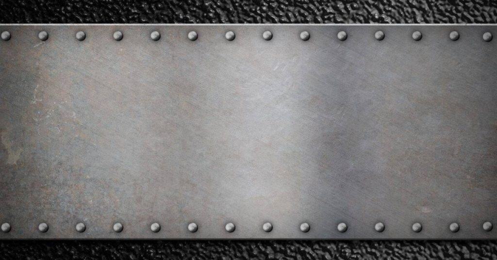 Metal sheet with rivets on textured dark surface