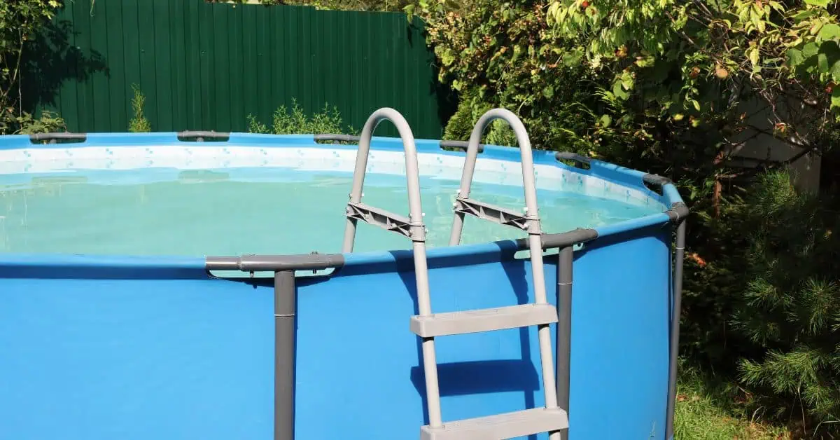 Above-ground blue pool with metal ladder in backyard