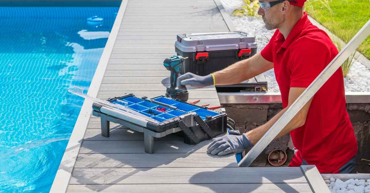 Man working near pool with toolboxes and power drill