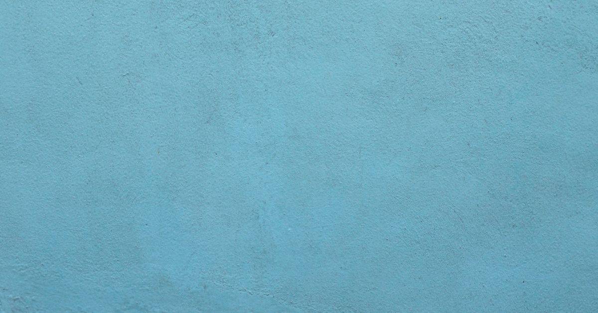 Close-up of textured blue painted stucco wall surface