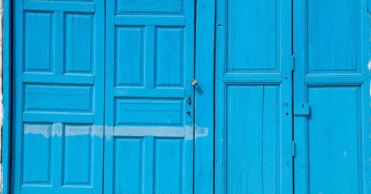 blue wooden doors with faded paint and patchy areas