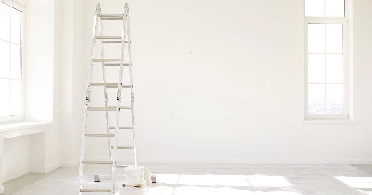 Aluminum ladder standing in empty bright white room