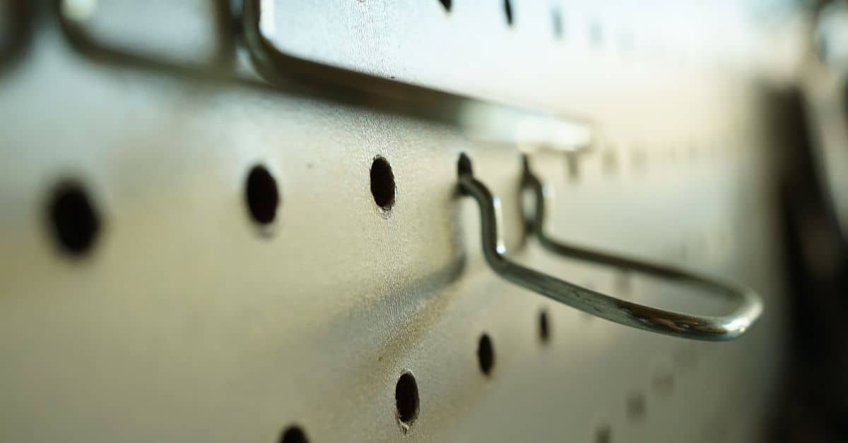 close up of metal pegboard with hooks inserted
