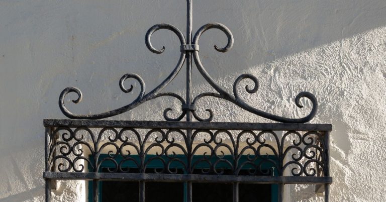 Decorative metal window grille mounted on textured wall