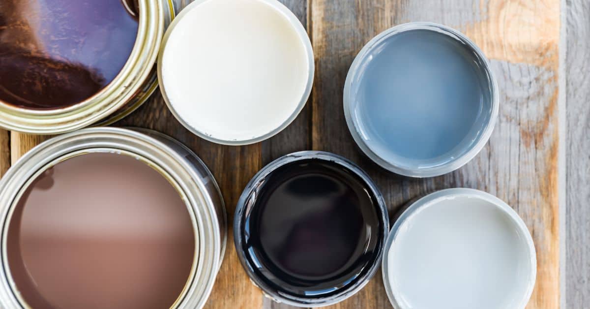Several open paint cans with different paint colors inside