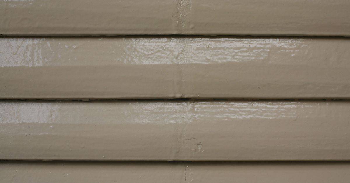 Closeup of painted wood siding with shiny clear coat finish