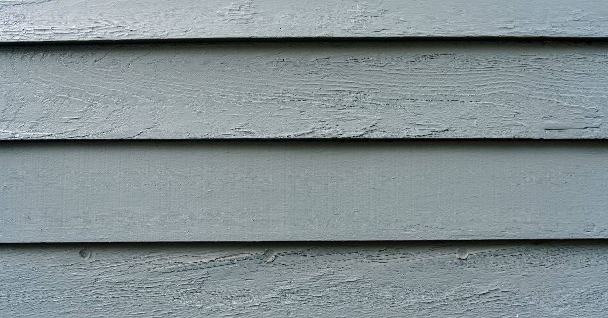 Closeup of painted wooden siding with smooth and textured surfaces
