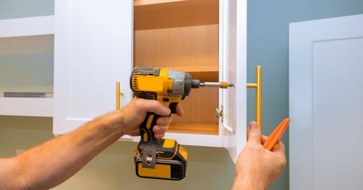 Person using drill to remove kitchen cabinet door handle