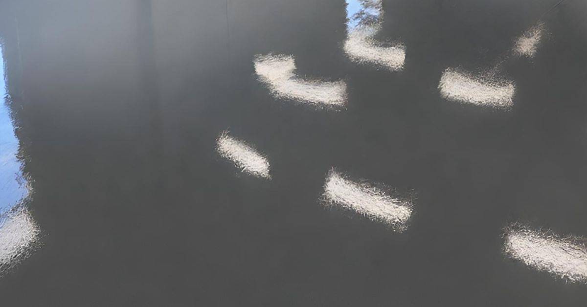 Glossy dark floor surface with visible light reflections