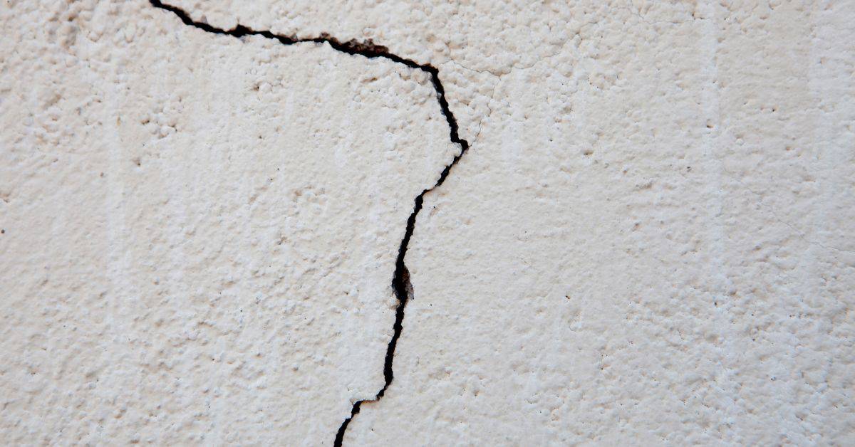 closeup of crack on textured stucco wall surface