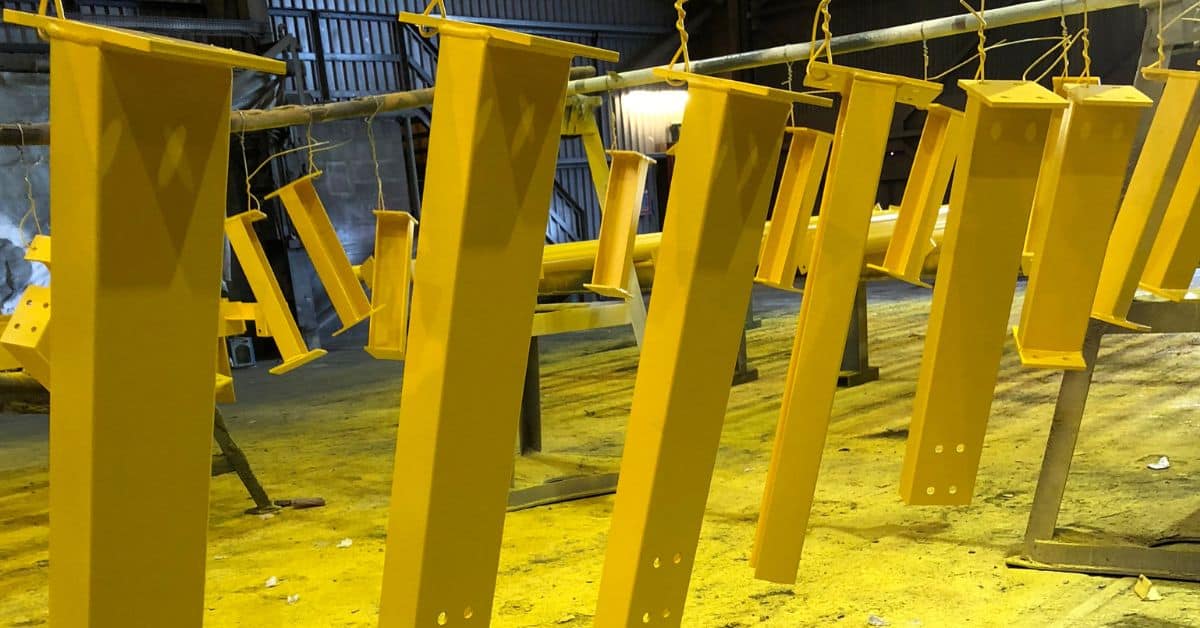 Yellow painted steel beams hanging in a workshop