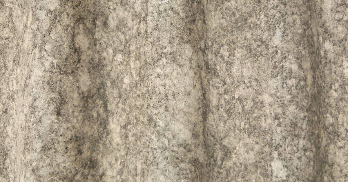 Close-up of corrugated textured plaster surface with varying color tones