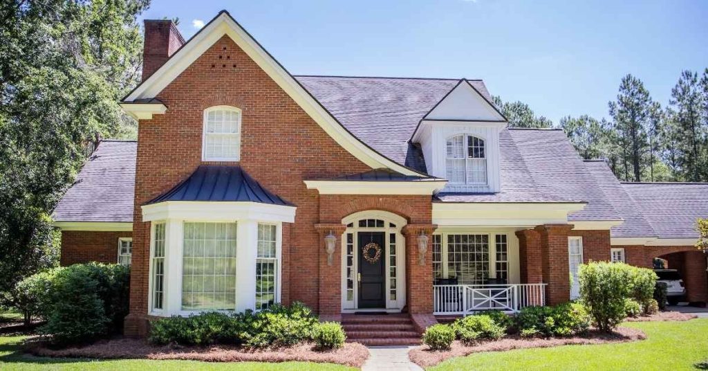 Red brick house exterior with white trim and black front door