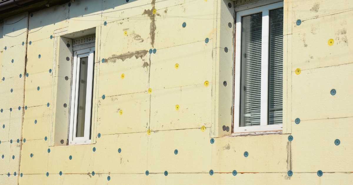 Exterior wall with yellow insulation foam boards and fasteners