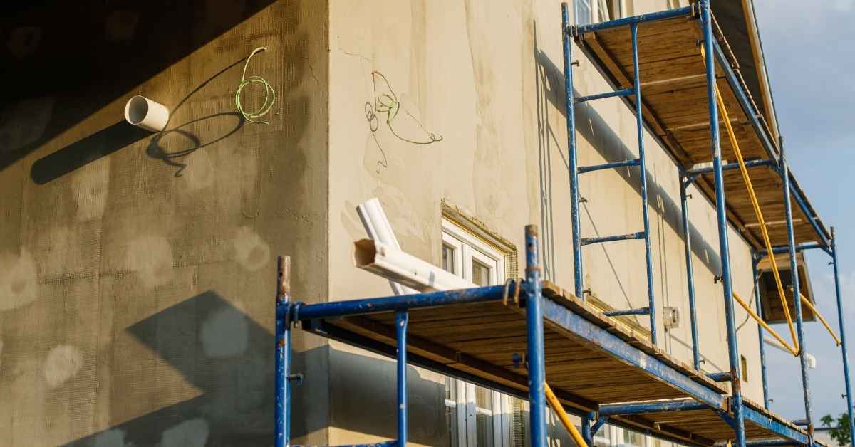 Building exterior with scaffolding and partially applied stucco